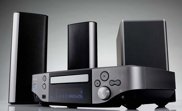 Denon S-302 DVD system with speakers on gray background.