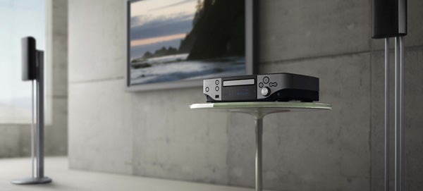 Denon S-302 DVD system with speakers in modern living room.Denon S-302 DVD system on modern glass table.