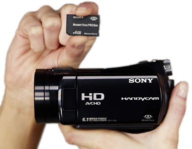 Hand holding Sony HDR-CX6EK camcorder with MemoryStick.