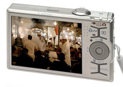 Canon IXUS 90 IS camera displaying a busy market scene.Canon IXUS 90 IS camera with photo on display screen.