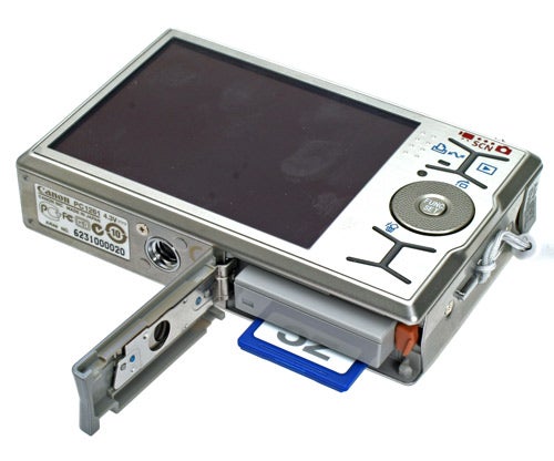 Canon IXUS 90 IS digital camera with open battery compartment.Canon IXUS 90 IS camera with open battery compartment.