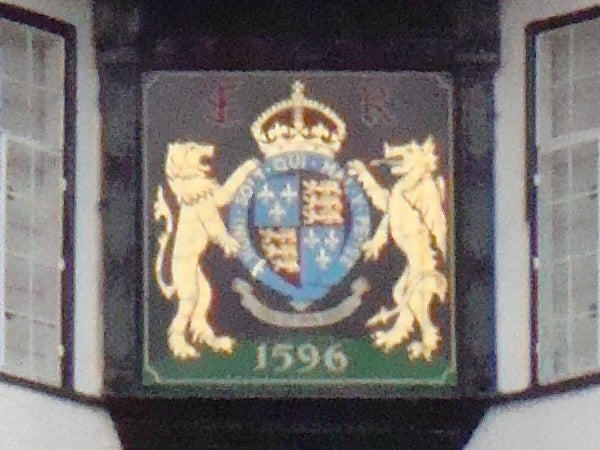 Crest with lions and crown, date 1596, on a building facade.photo of an emblem with lions and a crown.