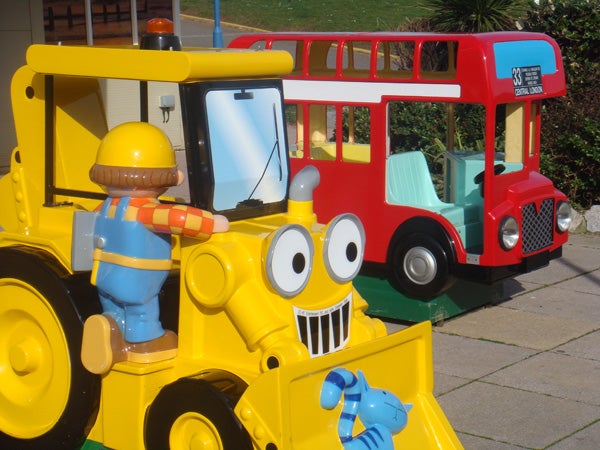 Colorful children's ride-on construction vehicle and bus.Brightly colored toy vehicles with cartoonish designs.