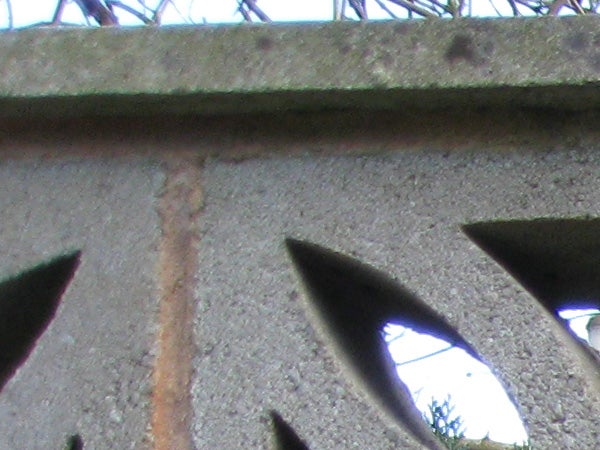 photo of a concrete structure with cut-out shapes.photo of a building's edge and iron fence.
