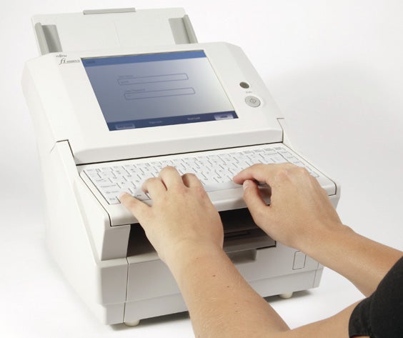 Person typing on Fujitsu fi-6000NS network scanner keyboard.