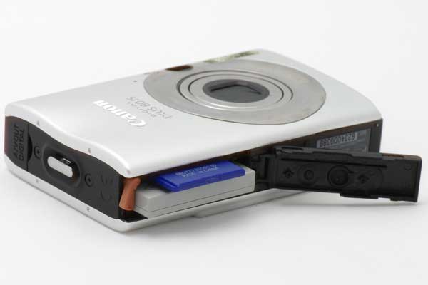 Canon IXUS 80 IS camera with open battery compartment.
