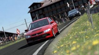 Red car racing on track in Gran Turismo 5 Prologue game.