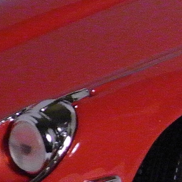 Close-up of a red car with chrome details.Close-up of red car detail with chrome accent