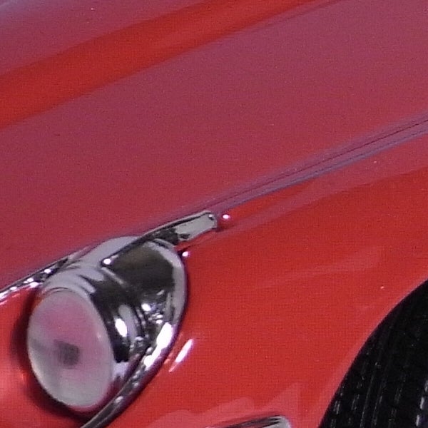 Close-up of a shiny car hood and headlight.Close-up of a red car's shiny chrome handle.