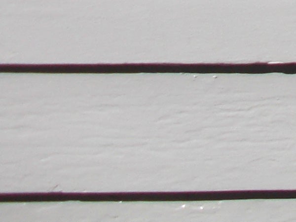 Close-up of two thin lines with a textured background.Close-up photo of two purple wires against white background.
