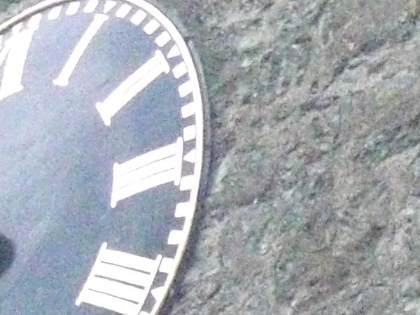 close-up of a watch face against a rock background.close-up of a clock face against a rocky background.