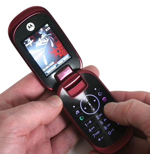 Hand holding open red Motorola U9 phone.Hand holding open Motorola U9 mobile phone.