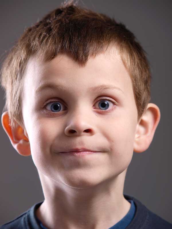 Close-up portrait of a young boy with neutral background.Close-up portrait of a young boy with a neutral expression.