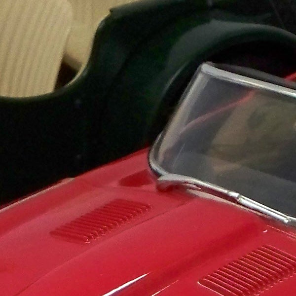 Close-up of a red toy car captured by Kodak camera.Close-up of red toy car with background