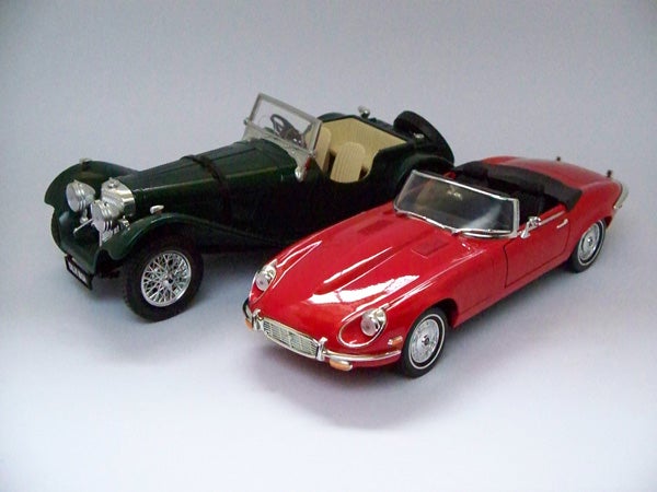 Photograph of two model cars, green and red, taken with Kodak EasyShare Z1085 IS.Two toy cars photographed on a white background.