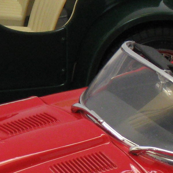 Close-up of a red toy car against a green background.Close-up of a red toy car with clear windshield