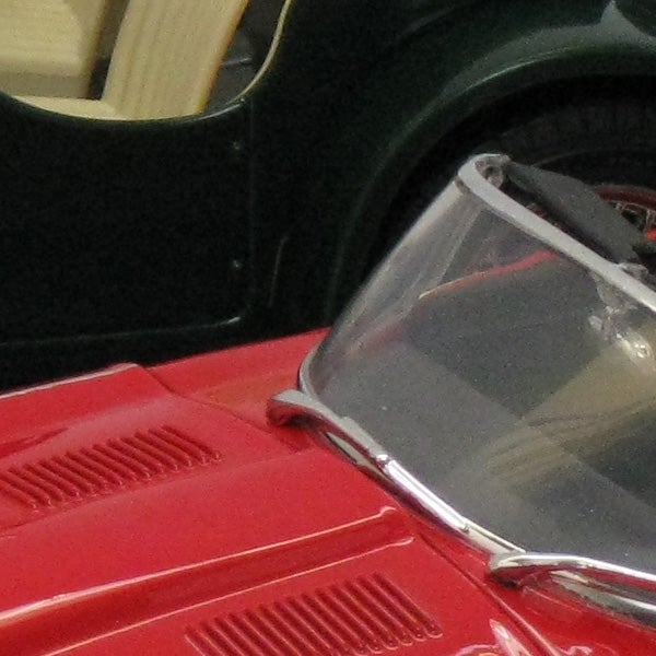 Close-up of red vintage car with clear windshieldClose-up of a red vintage car's rear and windshield