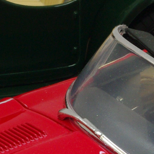 Close-up of a red toy car with a clear windshield.Close-up of a red toy car's front end