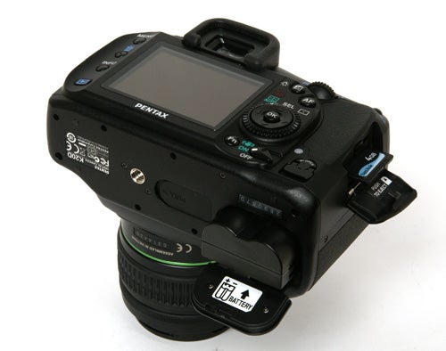 Pentax K20D DSLR camera with open memory card slot.Pentax K20D DSLR camera with lens on white background.