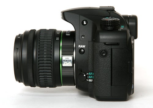 Pentax K20D DSLR camera with lens on white background.