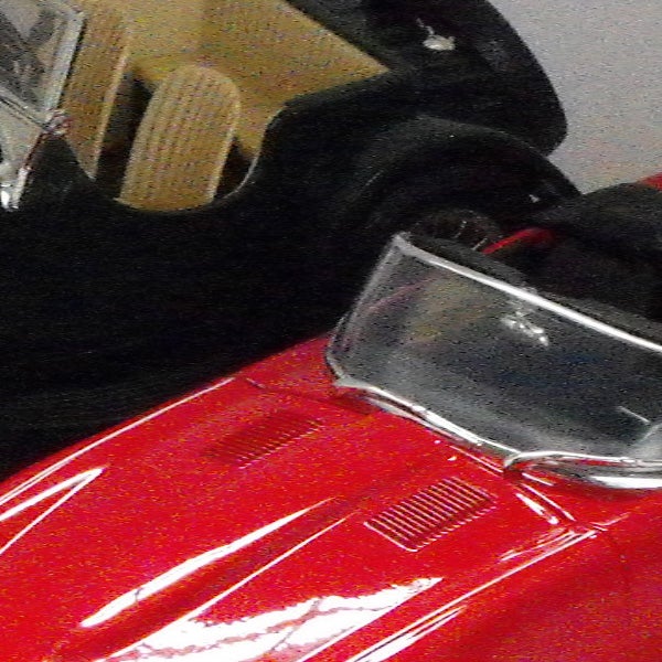 Close-up of red vintage car with reflective surfaces.Close-up of vintage red car model