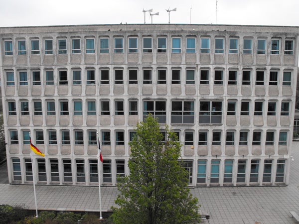Office building exterior with multiple windows and two flags.Office building with multiple windows and two flags.