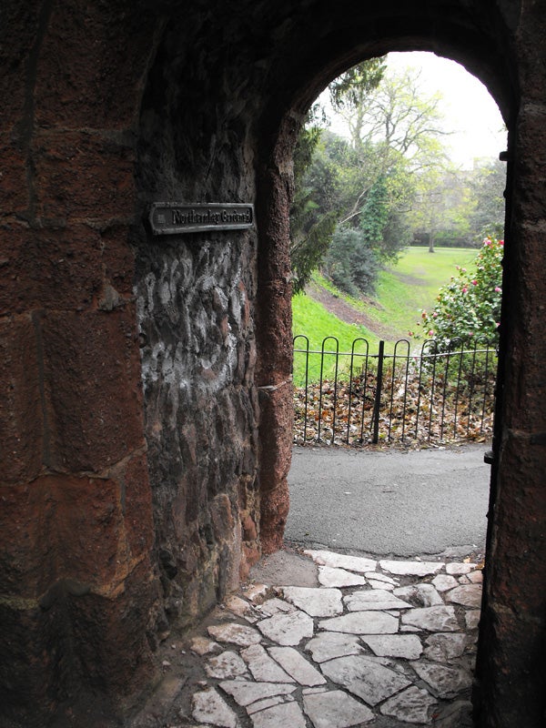 Stone archway leading to a garden path with greeneryStone archway entrance to a garden