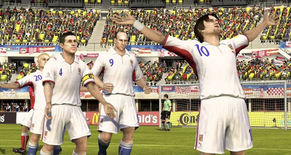 Animated football players celebrating a goal in a video game.Screenshot of UEFA Euro 2008 video game featuring animated players.