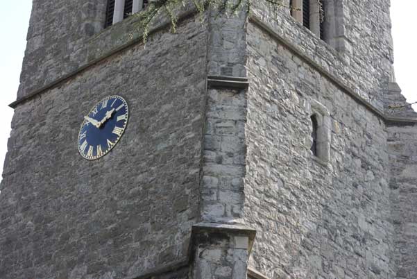 Church tower with a clock photographed in daylight.Photo of a church tower with a blue clock, taken during daytime.