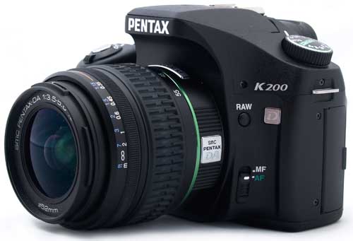 Pentax K200D DSLR camera with lens on white background.