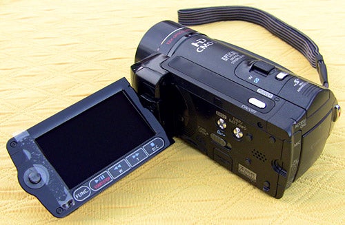 Canon HF10 camcorder with flip-out LCD screen.Canon HF10 camcorder with flip-out LCD screen on yellow background.