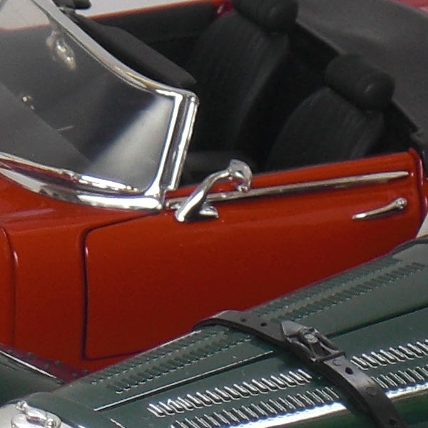 Close-up of scale model cars with shiny detailsClose-up of red and green toy cars' doors and windshields.