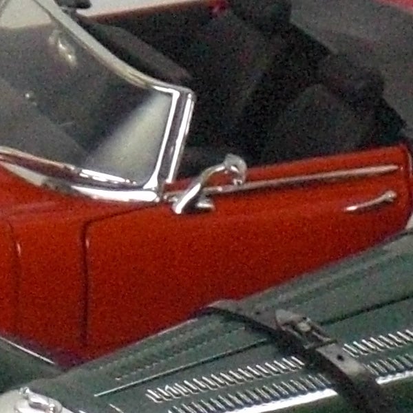 Close-up of a red car door and chrome handle.Close-up of a vintage red car's side door and mirror.