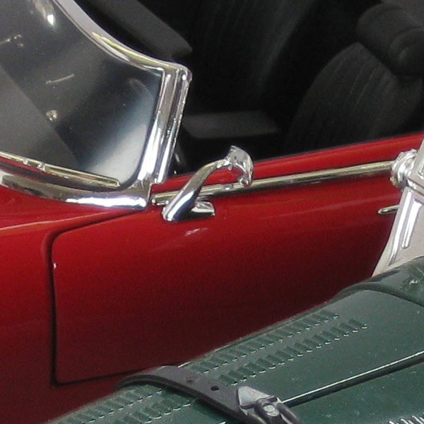 Close-up of a red classic car model detail.Close-up of a red vintage car model's side detail.