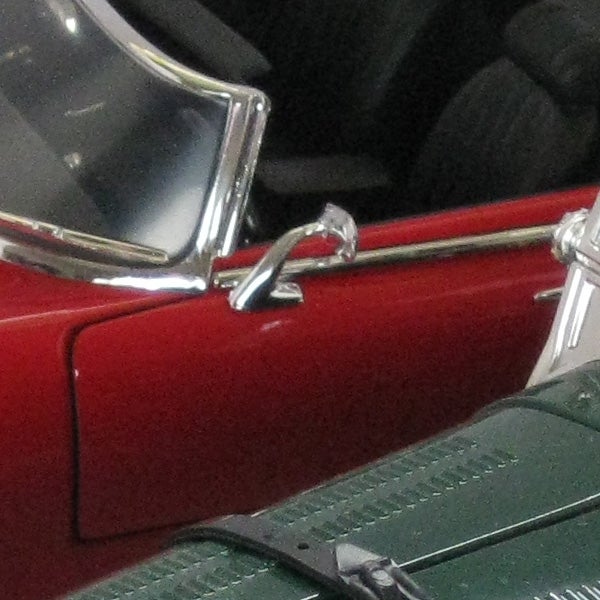 Close-up of a red car door and chrome handle.Close-up of a classic red car door and side mirror.