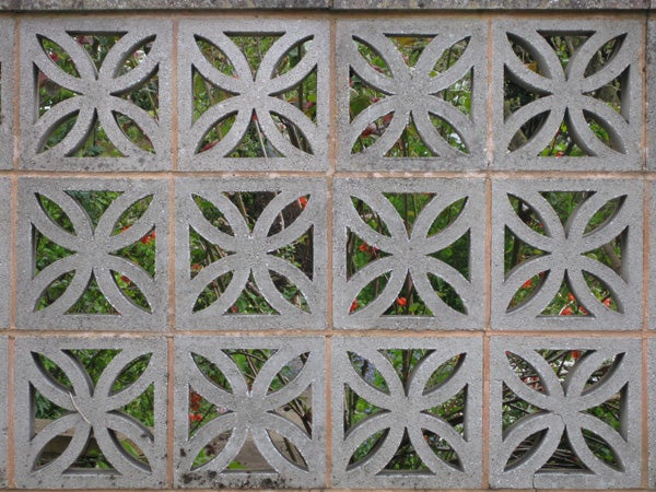 Decorative concrete block wall with floral patternsDecorative stone wall with symmetrical floral patterns.