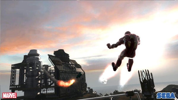 Iron Man video game screenshot with flying character.Iron Man flying over industrial buildings in the video game.