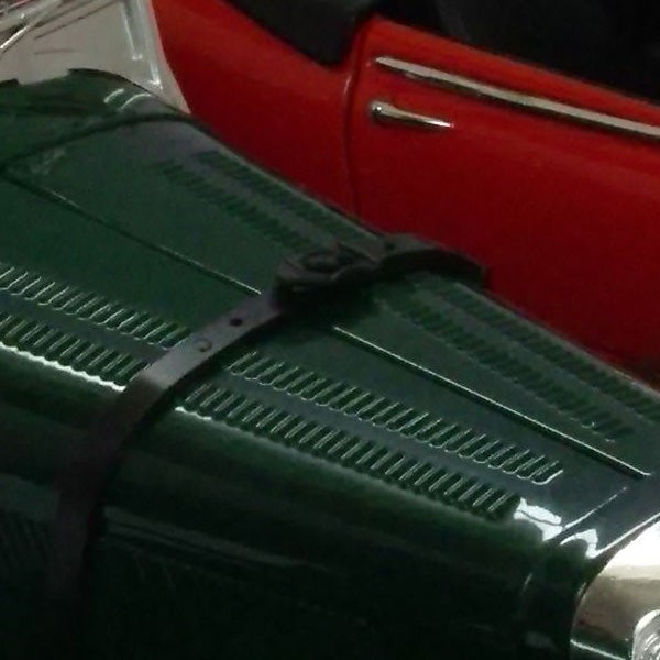 General Electric E840s camera on green luggage with red car behind.image of a green surface with black strap, red car in background