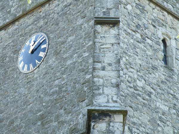 Close-up of a clock on an old stone tower facade.Fujifilm Finepix S8100fd sample photograph of a clock tower.