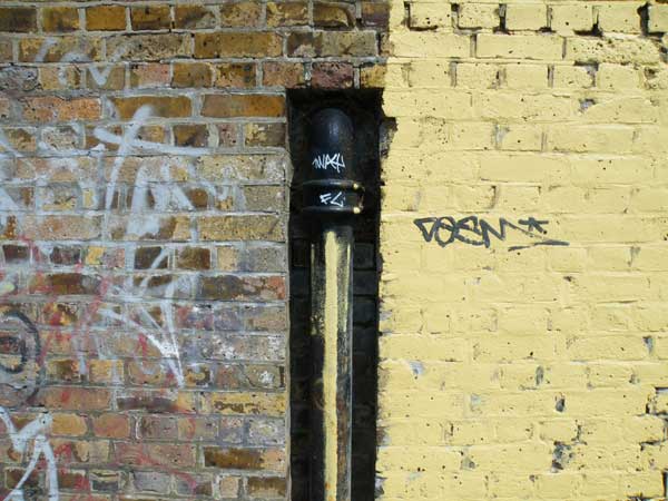 Graffiti on urban wall with drainpipe