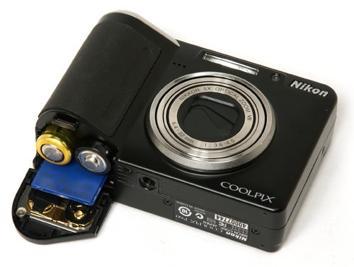 Nikon CoolPix P60 camera with open battery compartment.