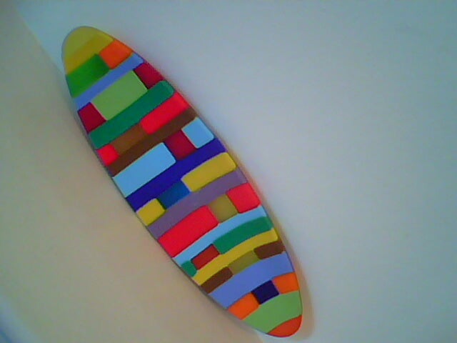Colorful surfboard with a multicolored pattern design.
