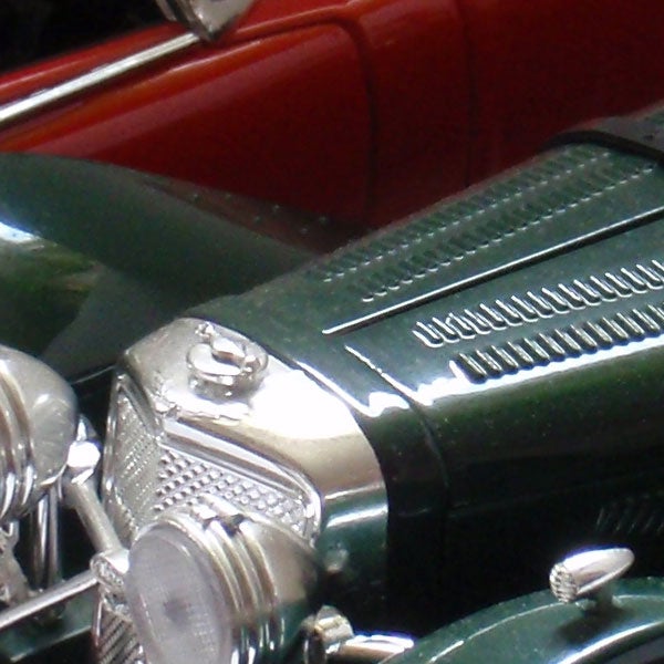 Close-up of a vintage car model in green and redClose-up of a vintage green car model.