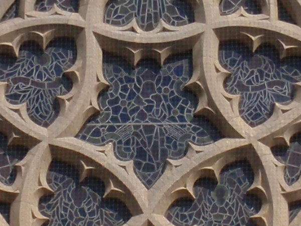 Intricate stone lattice pattern on building facadeClose-up of intricate stone lattice work on building facade.