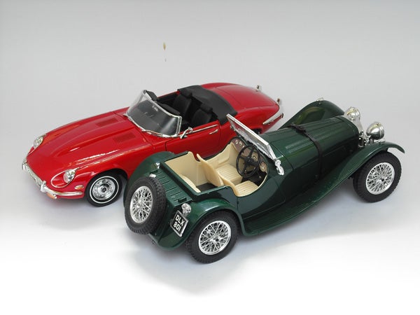 Two vintage model cars on a white background.Two vintage model cars, one red and one green.
