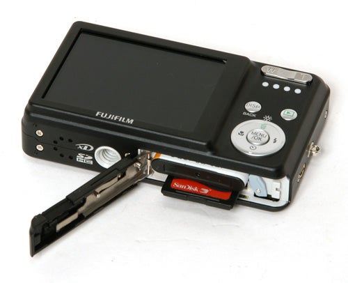 Fujifilm FinePix J10 camera with open memory card slot.Fujifilm FinePix J10 camera with open battery compartment.