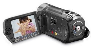 Canon FS11 camcorder with flip-out LCD screen displaying video.