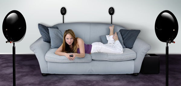 Woman relaxing on sofa with KEF KHT2005.3 speakers and subwoofer.Woman relaxing on couch with KEF KHT2005.3 speakers and subwoofer.