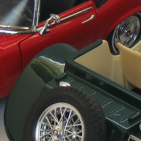 Close-up of a classic red car and green trailer model.Close-up of a red car and a green trailer toy models.