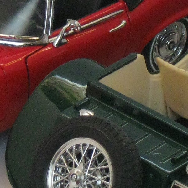 Close-up of a classic red car model with detailed features.Close-up photo of a red vintage car model.